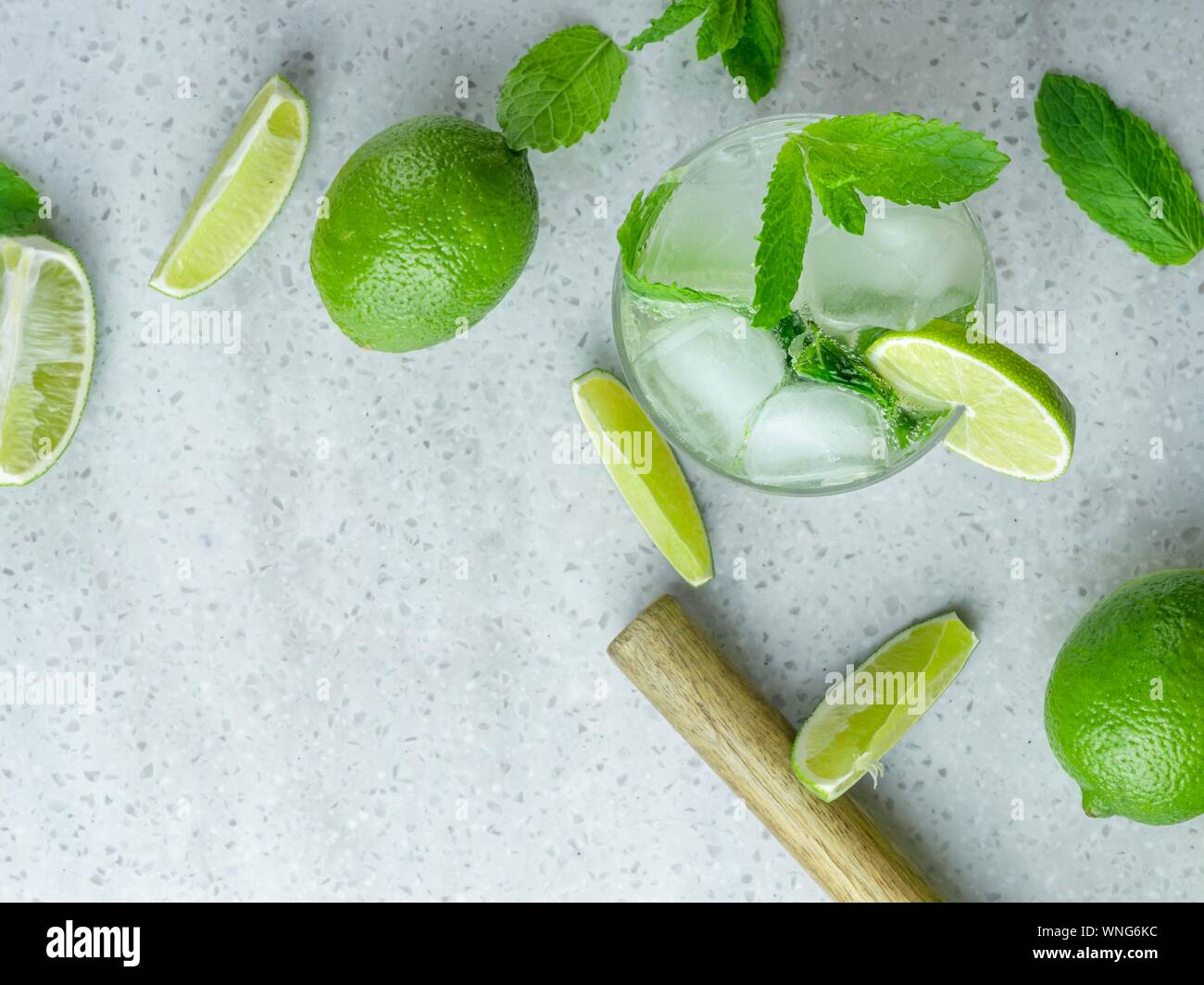 A top down view of a mojito cocktail made from fresh mint and lime in a cut glass tumbler against a pale background Stock Photo