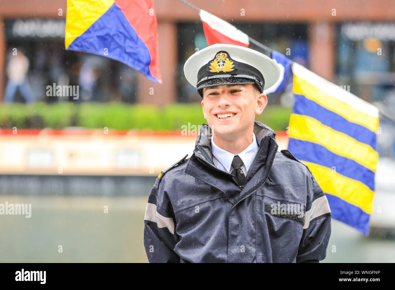 St. Katharine Docks, London, 06th Sep 2019. A crew member on the HMS Blazer, a Royal Navy training vessel, smiles as he welcomes visitors to look around the vessel. Classic boats and barges, decorated smaller vessels and water craft are moored in St. Katharine Docks for the annual Classic Boat Festival. The free festival also features food and drink stalls, stages, bands and free paddle boarding and other activities, and is on for three days until Sunday 8th September. Credit: Imageplotter/Alamy Live News Credit: Imageplotter/Alamy Live News Stock Photo