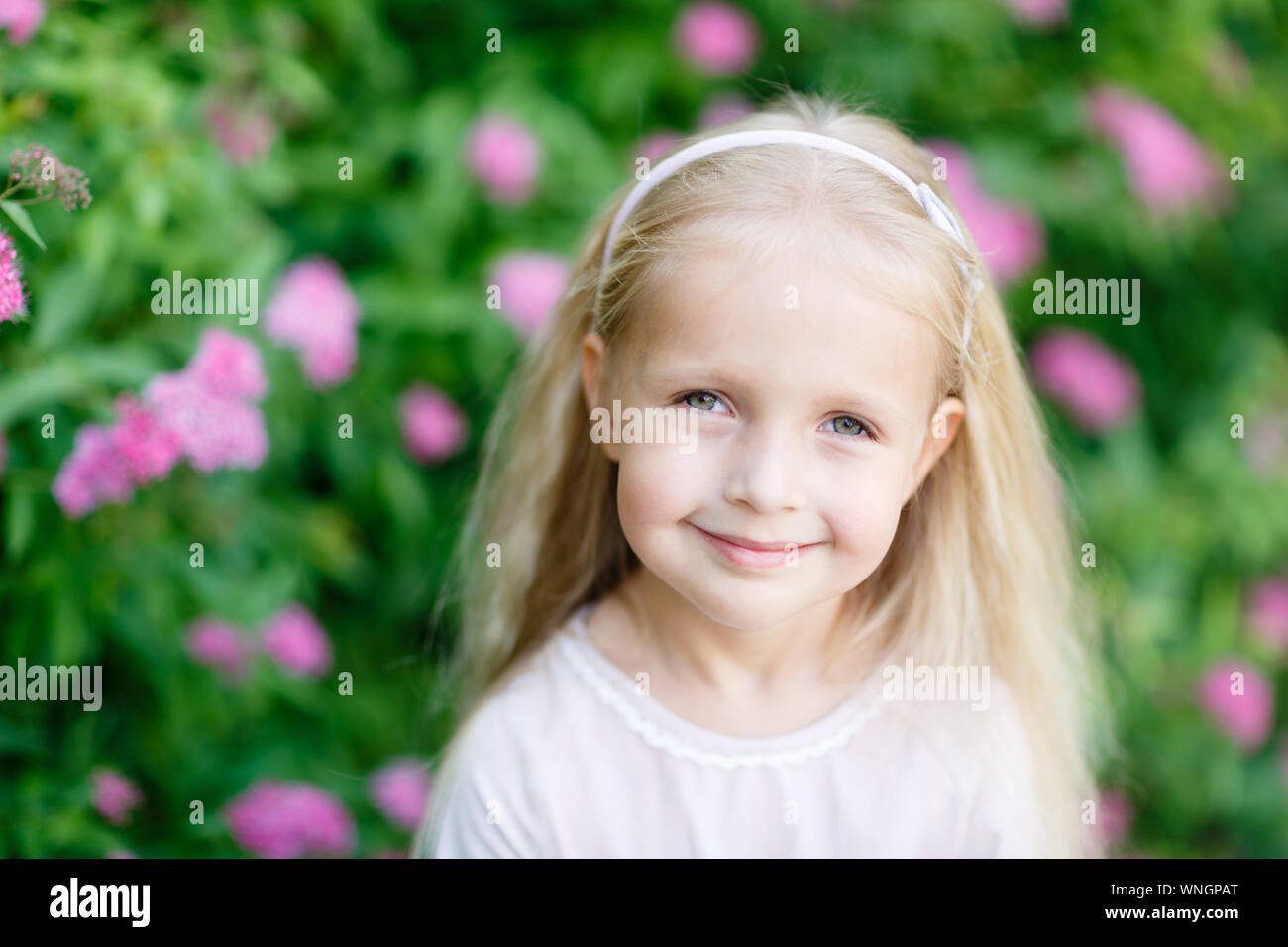 Cute Little Girl With Curly Blonde Hair On The Park In Summer Day