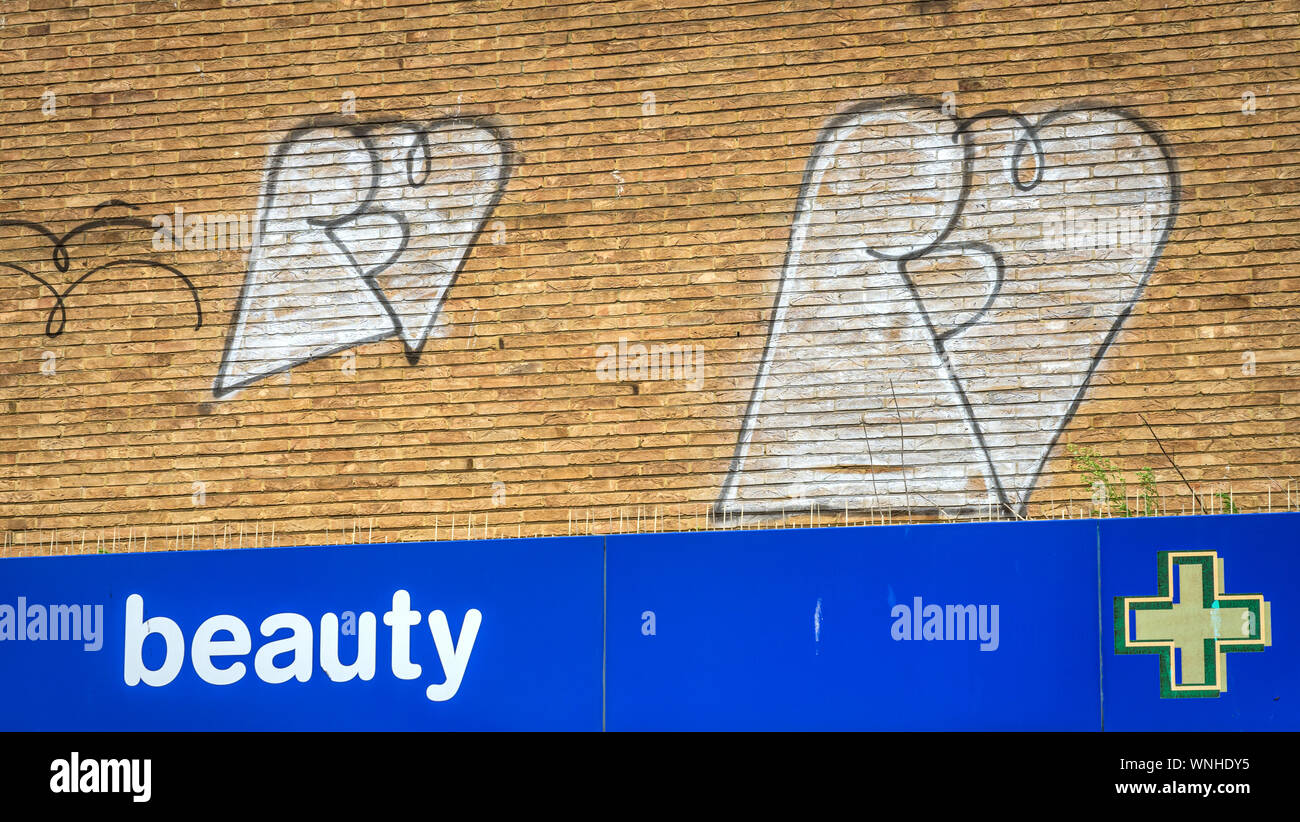 London Road, Brighton, UK 09/06/2019 Graffiti on shop wall over sign saying beauty Stock Photo