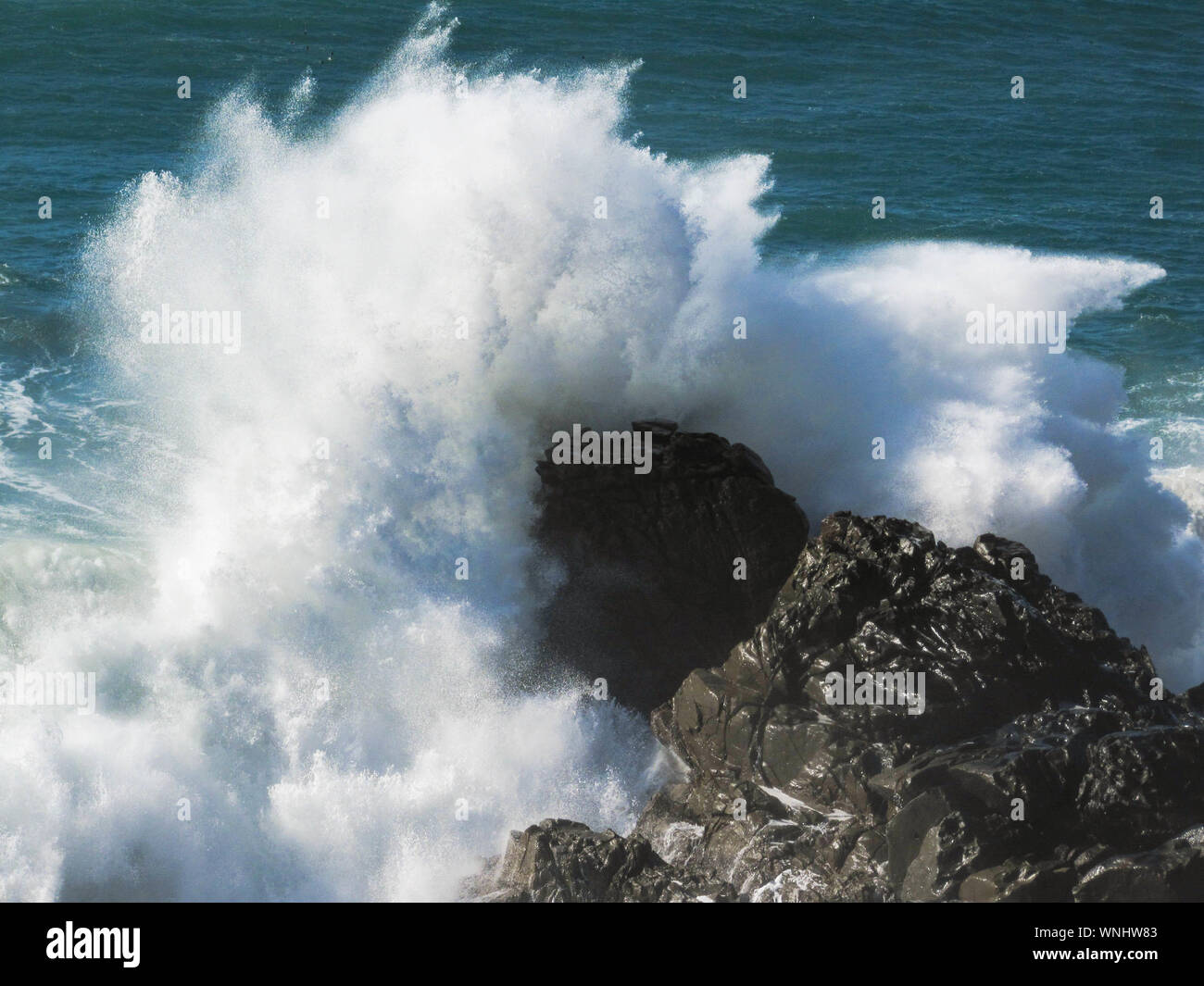 High Angle View Of Waves Crashing On Rocks At Shore Stock Photo