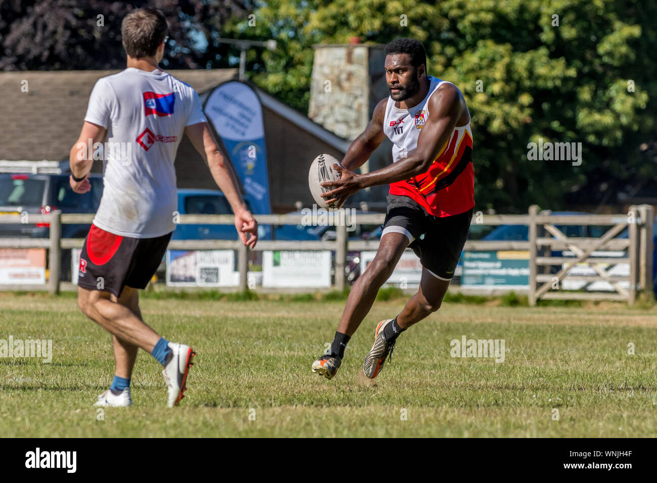 Amateur rugby touch player (male, 40-50 y) sidesteps younger male opponent Stock Photo