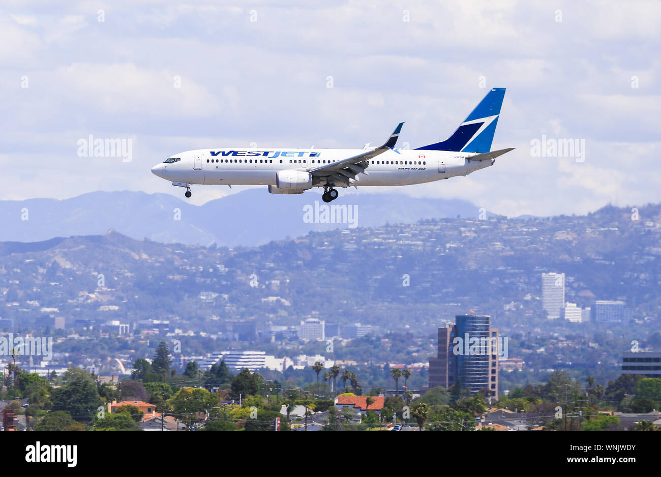 Los Angeles, California, USA - May 22, 2019: A WestJet Boeing 737 lands at the Los Angeles International Airport (LAX). In the background you can see Stock Photo