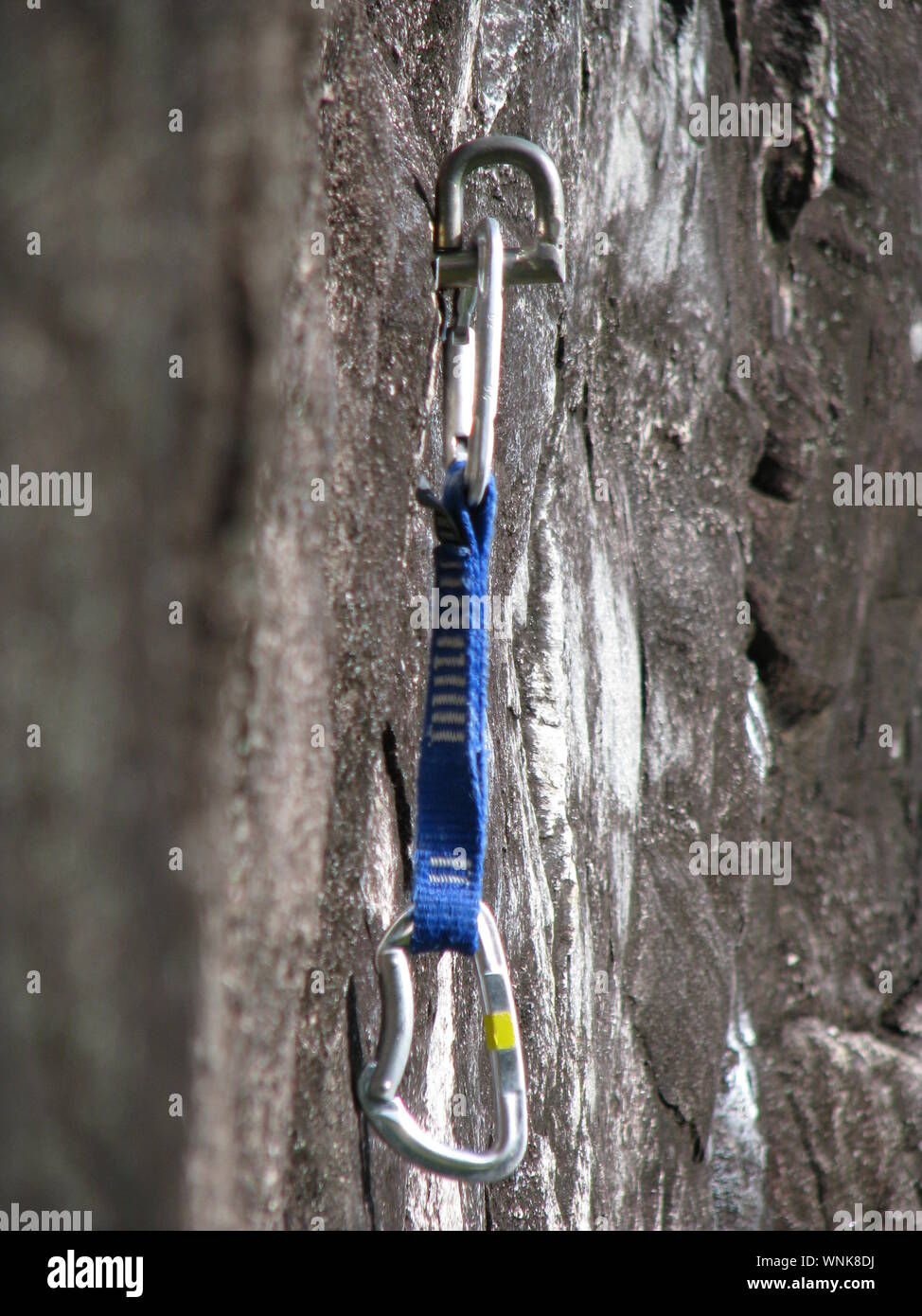 Close-up Of Safety Harness Hook Hanging On Rocks Stock Photo