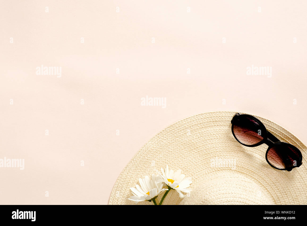 Flatlay composition with straw hat, daisy flowers and sunglasses on pastel pink background. Flat lay, top view, copy space. Summer fashion, vacation c Stock Photo