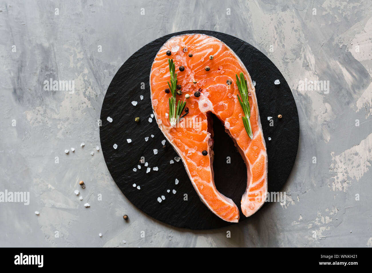 Fresh raw salmon fish steak with spices on dark stone background ...