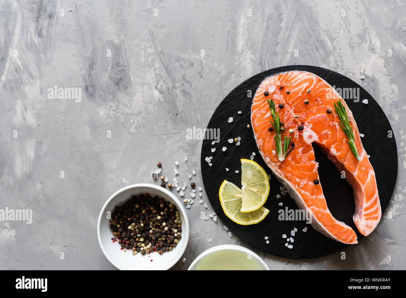Fresh raw salmon fish steak with spices on dark stone background ...