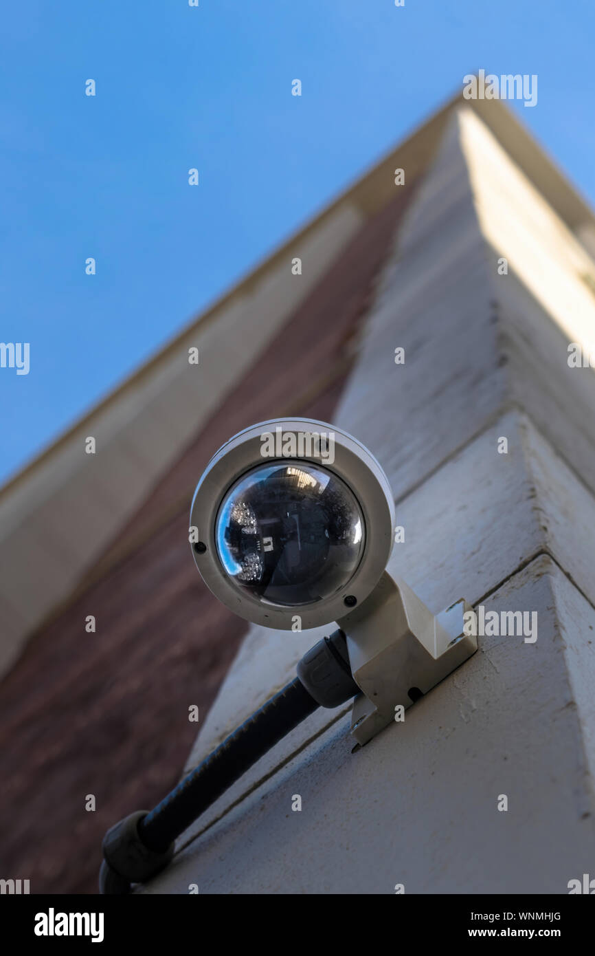 Surveillance camera mounted on the facade of a tall, modern building