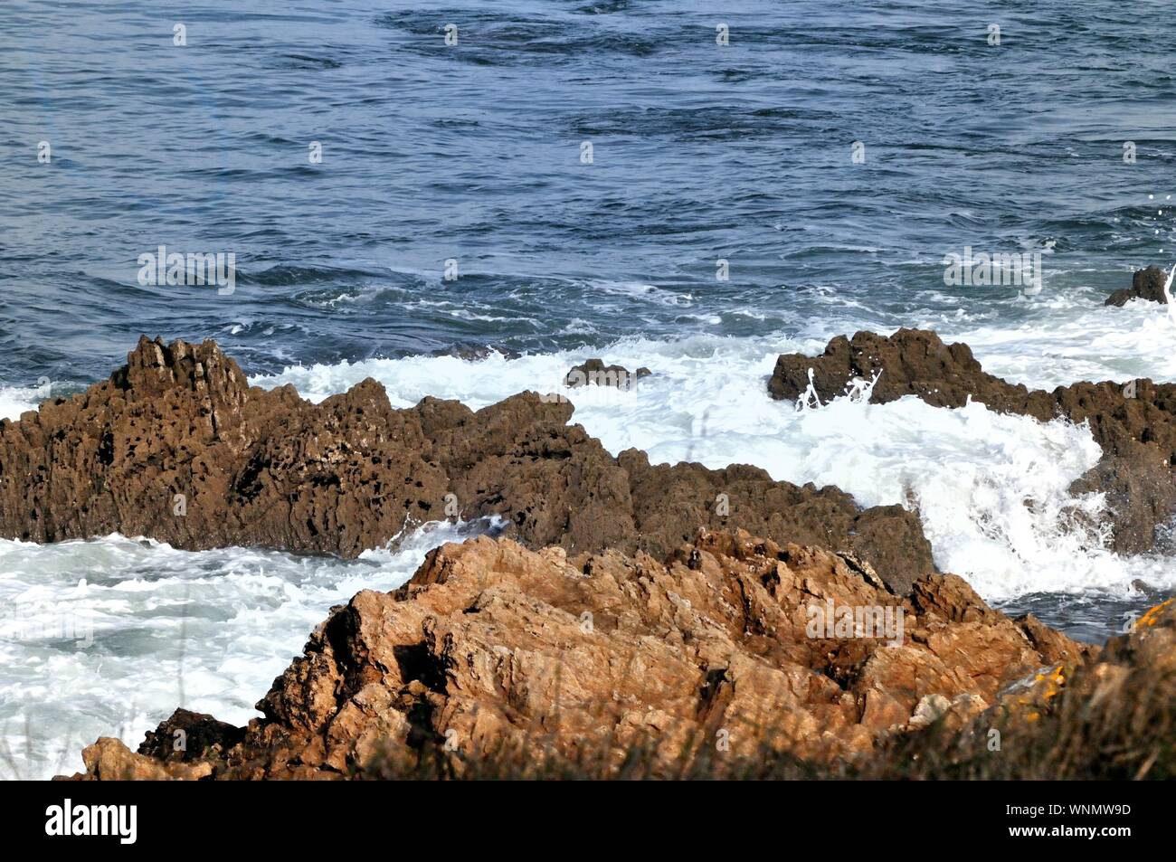 Waves of the Atlantic ocean hitting the french coast rocks and forming swirls in a peaceful but powerful atmosphere calling for Freedom and Infinity. Stock Photo