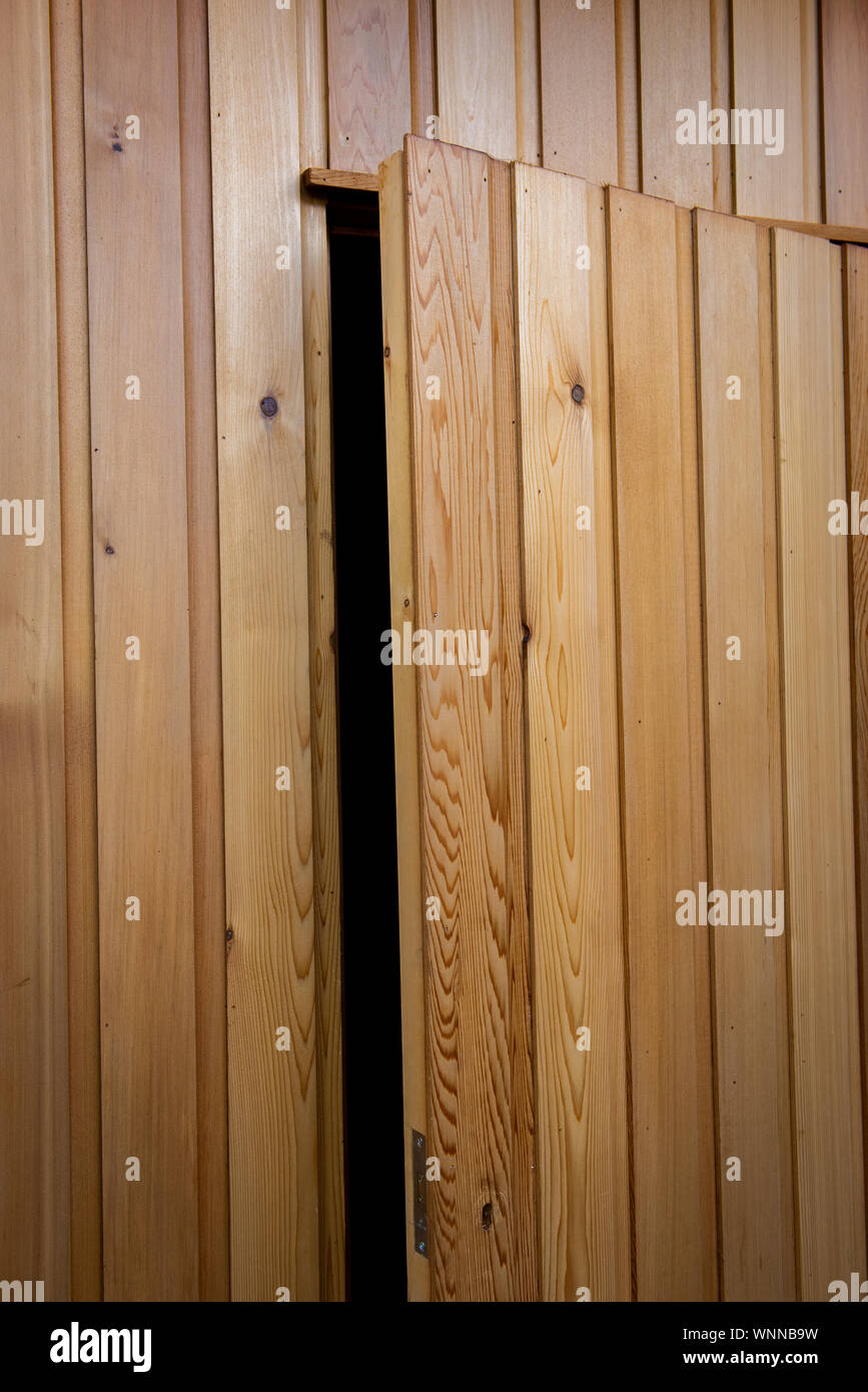 Oiled cedar timber cladding building with secret concealed door Stock