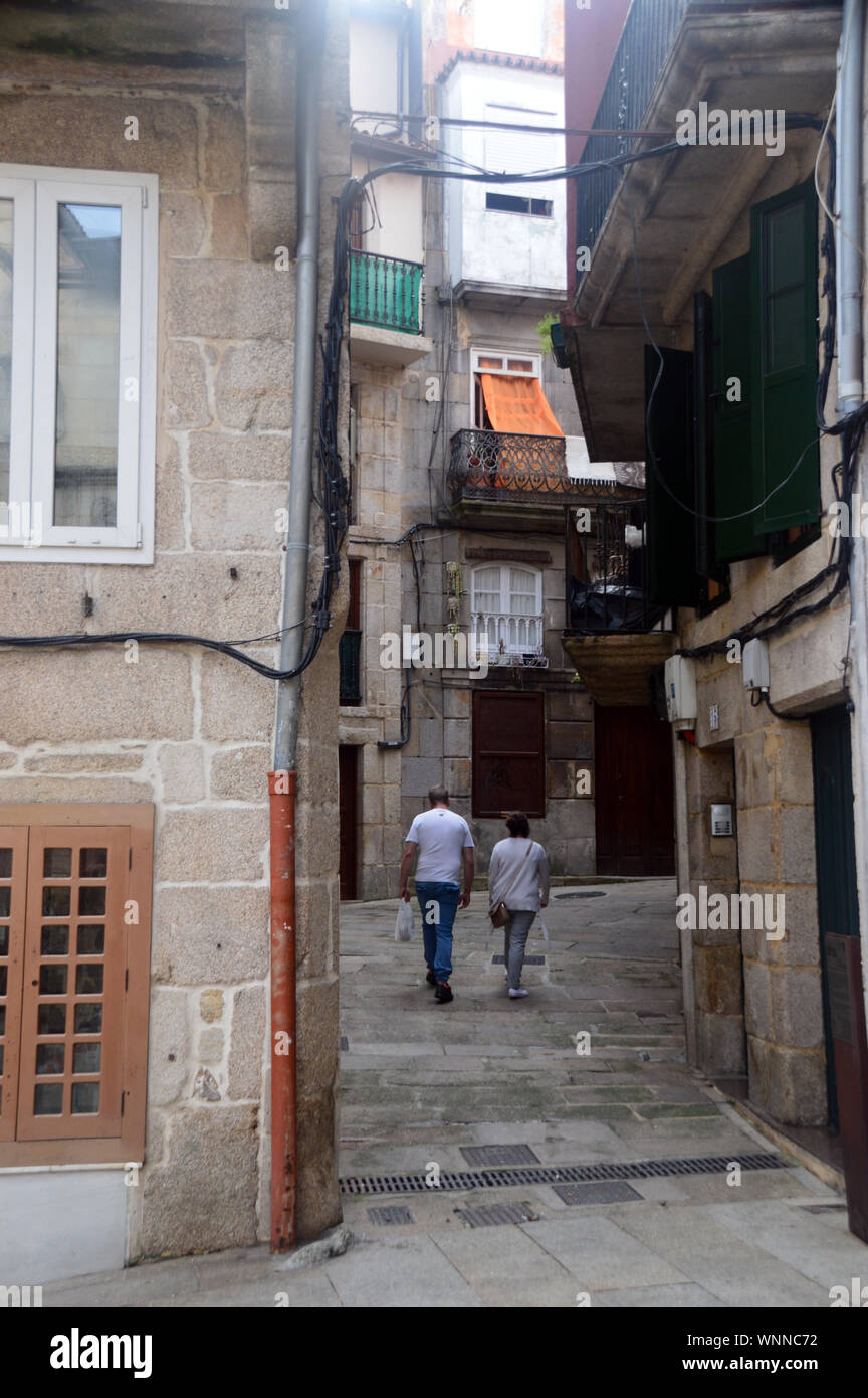 A Couple of Tourists Walking in the one of the Tiny Narrow Streets in the Old Town of Vigo, North West Spain, EU. Stock Photo