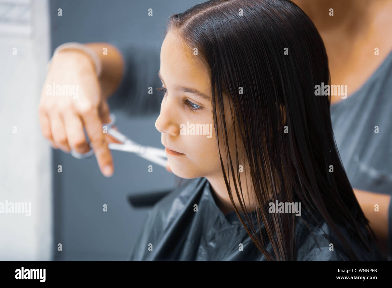 Madre cortando el cabello a su hija en casa Stock Photo