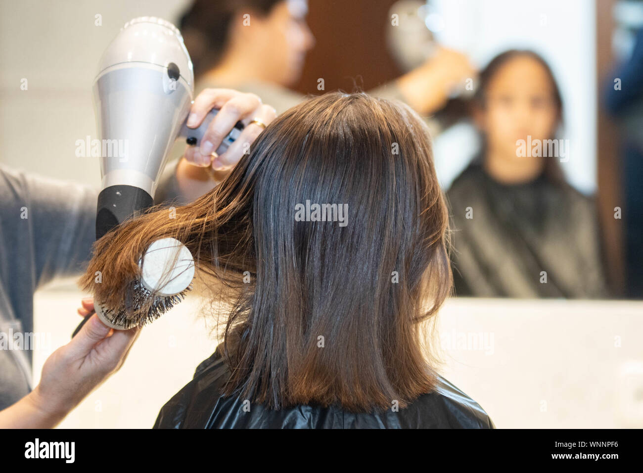 Madre cortando el cabello a su hija en casa Stock Photo