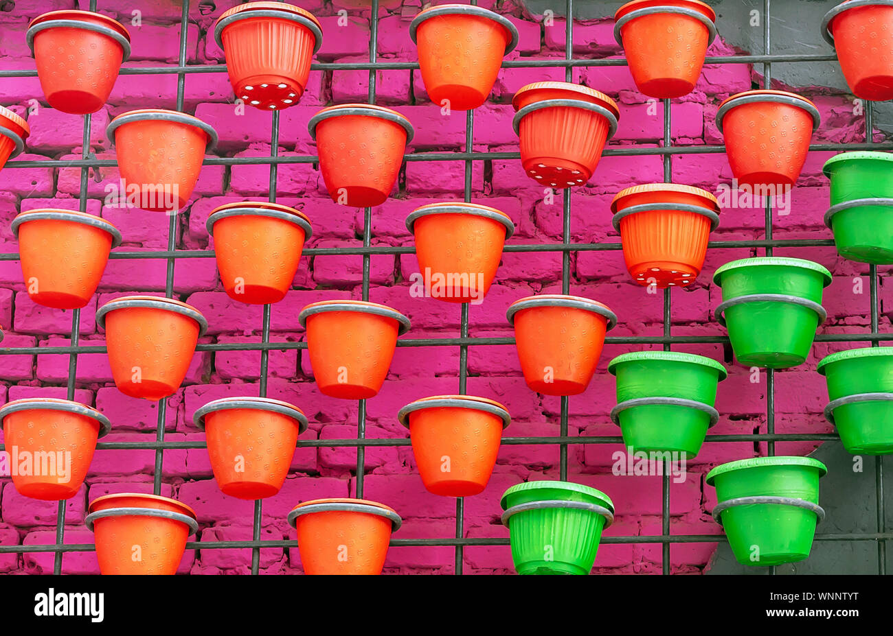 Plastic flower pots on a brick wall background. Stock Photo