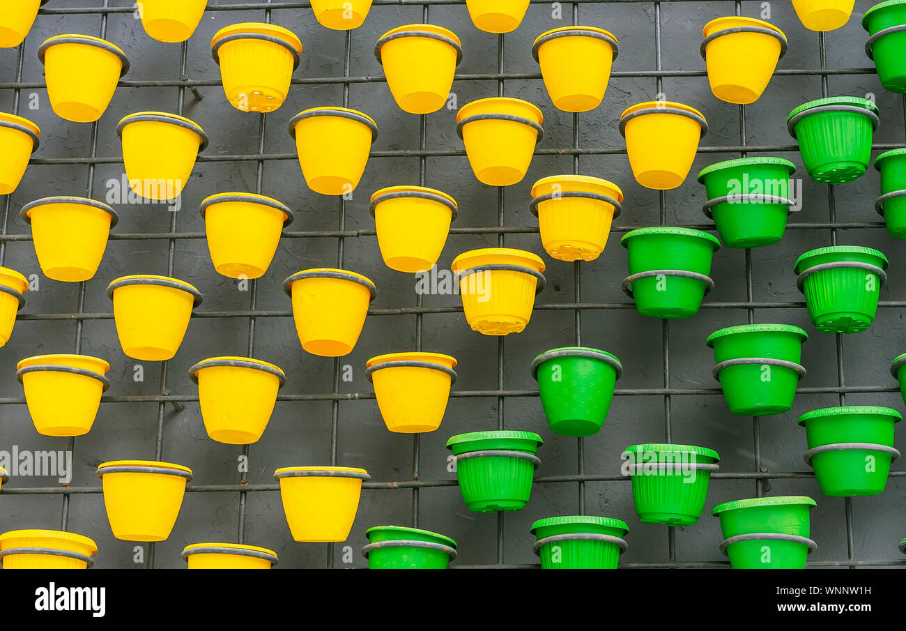 Plastic flower pots on a brick wall background. Stock Photo