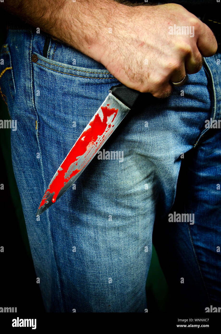 Midsection Of Murderer Holding Blooded Knife Stock Photo