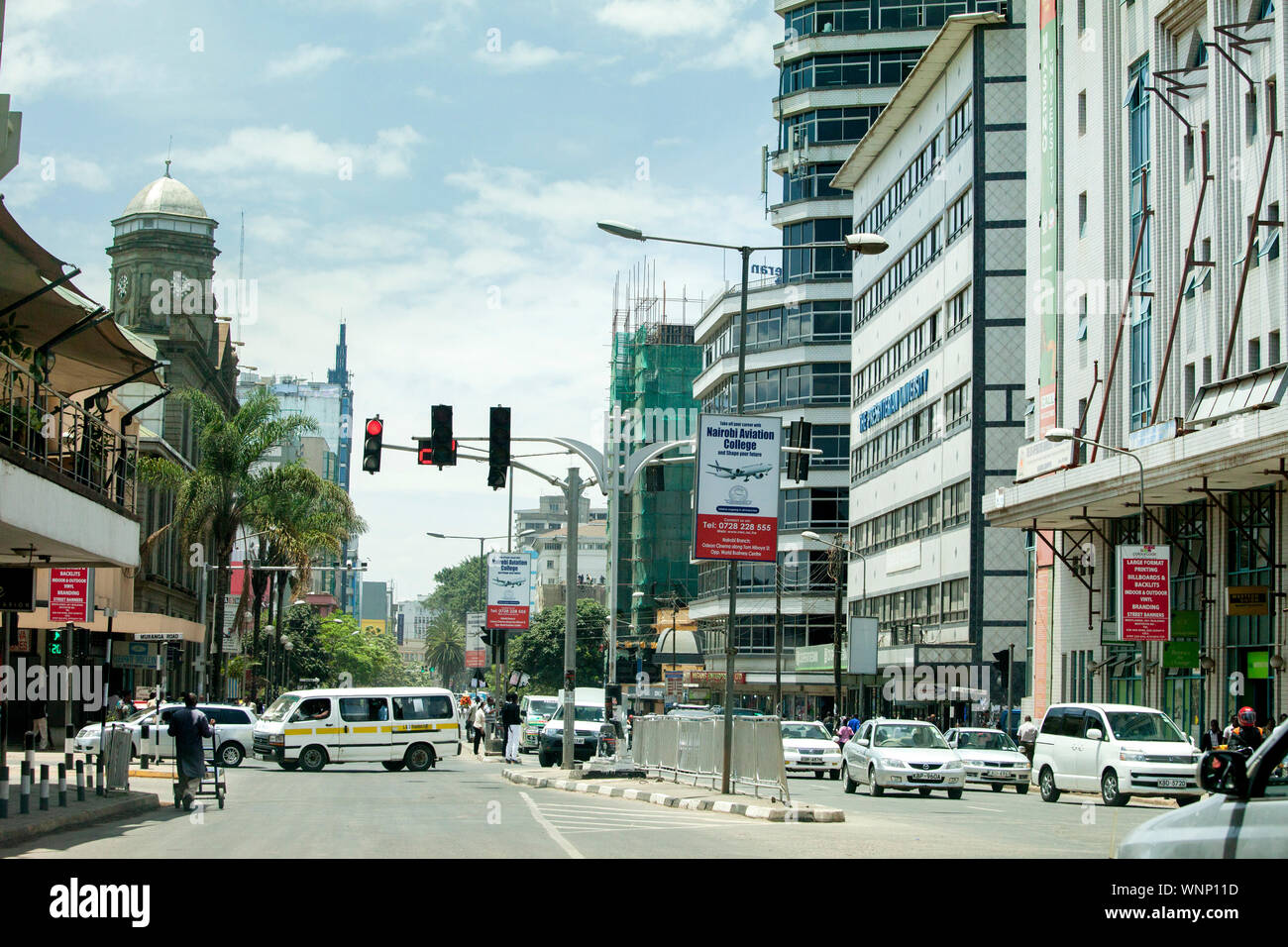 NAIROBI, KENYA-SEPTEMBER 15, 2014: Unidentified people walk in the downtown area with heavy traffic in Nairobi, Kenya Stock Photo