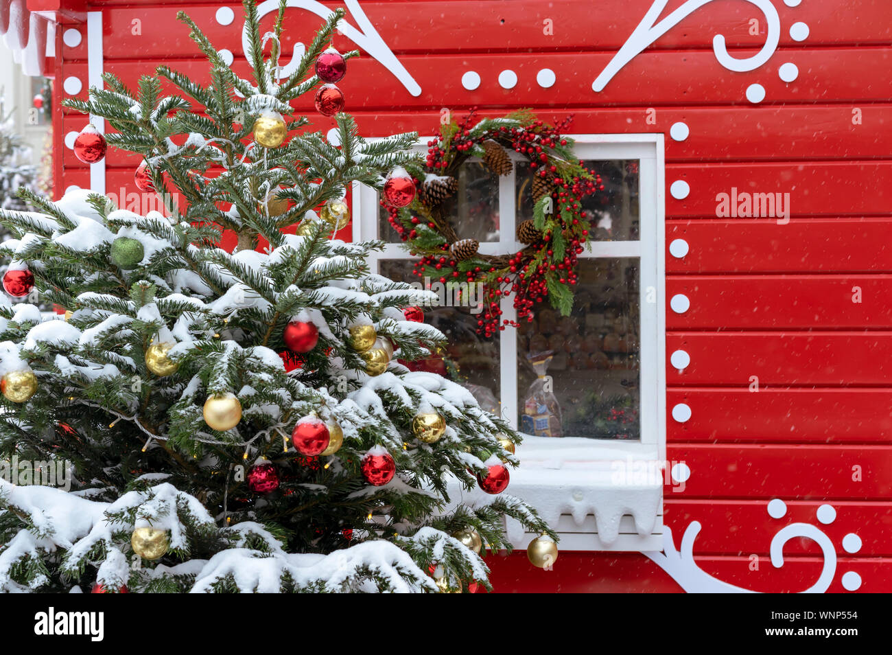 Decorated Christmas tree on the background of a red fairytale house ...
