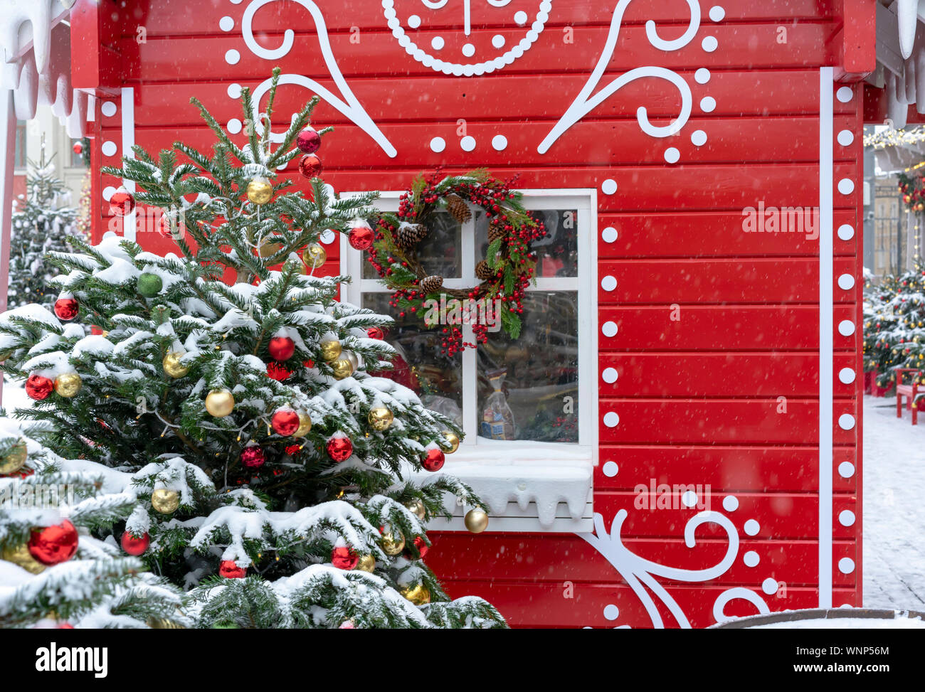 Decorated Christmas tree on the background of a red fairytale house ...