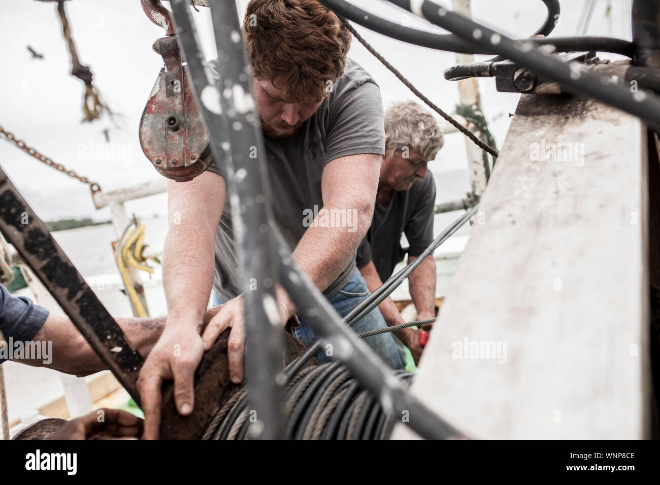 Commercial fishermen working on the deck of a ship Stock Photo