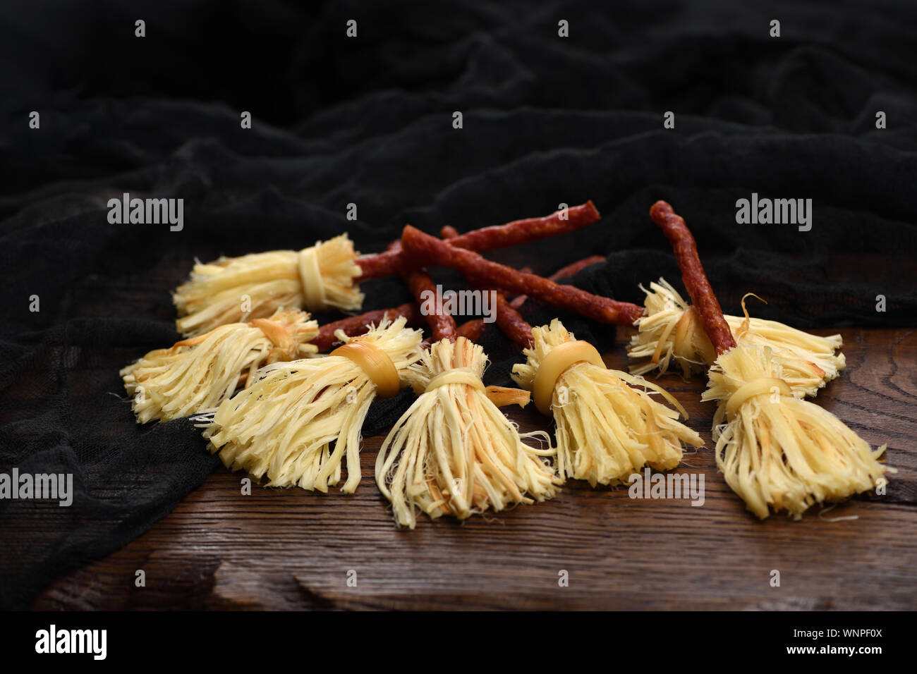 Witches Broom of smoked cheese suluguni and salami. Original idea Halloween snack. Stock Photo