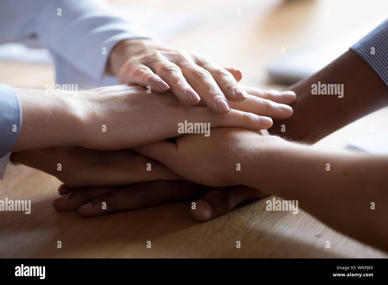 Close up of diverse employee stack hands showing unity Stock Photo - Alamy