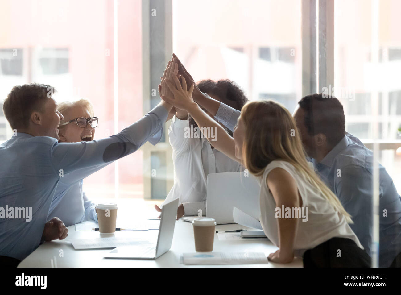 Excited diverse colleagues give high five at meeting Stock Photo - Alamy