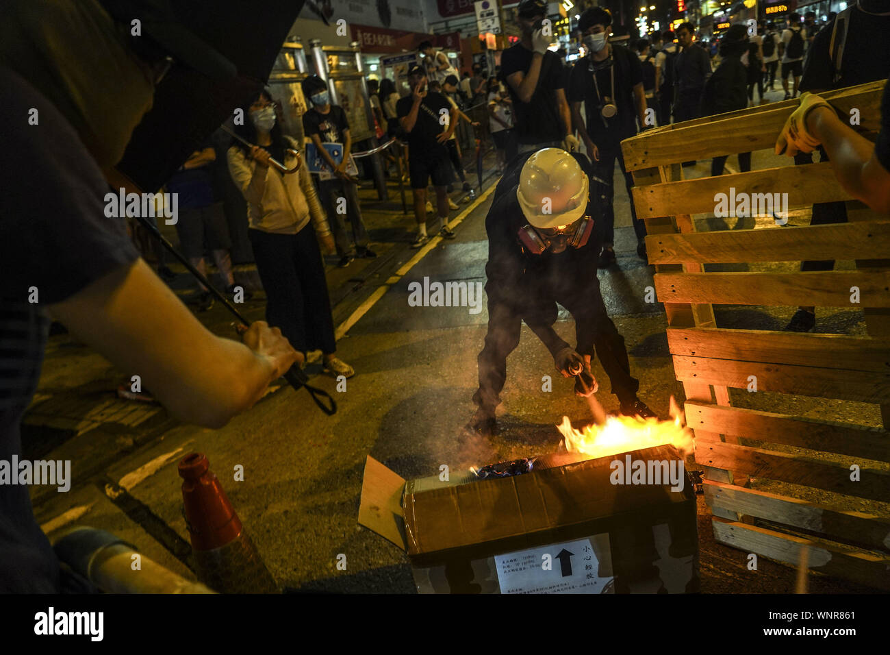 Kowloon, Hong Kong. 6th Sep, 2019. A protester ignites a spray can to set barricade on fire on Friday September 6, 2019.in Mong Kok Town Kowloon, Hong Kong.Thousands of protestors gathered outside of Mong Kok police station and around that area to protest the police violence against citizens of Hong Kong.Protesters Moved Nathan Rd to south, destroying surveillance cameras, street signs, building barricades with wooden panes and garbages then set on fire as they move on.9/6/2019.Kowloon, Hong Kong. Credit: ZUMA Press, Inc./Alamy Live News Stock Photo