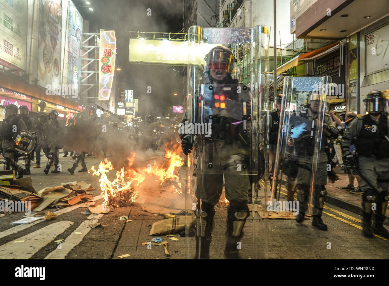 Kowloon, Hong Kong. 6th Sep, 2019. Riot police officers surround garbage fire which was set by protestors on Friday September 6, 2019.in Mong Kok Town Kowloon, Hong Kong.Thousands of protestors gathered outside of Mong Kok police station and around that area to protest the police violence against citizens of Hong Kong.Protesters Moved Nathan Rd to south, destroying surveillance cameras, street signs, building barricades with wooden panes and garbages then set on fire as they move on.9/6/2019.Kowloon, Hong Kong. Credit: ZUMA Press, Inc./Alamy Live News Stock Photo