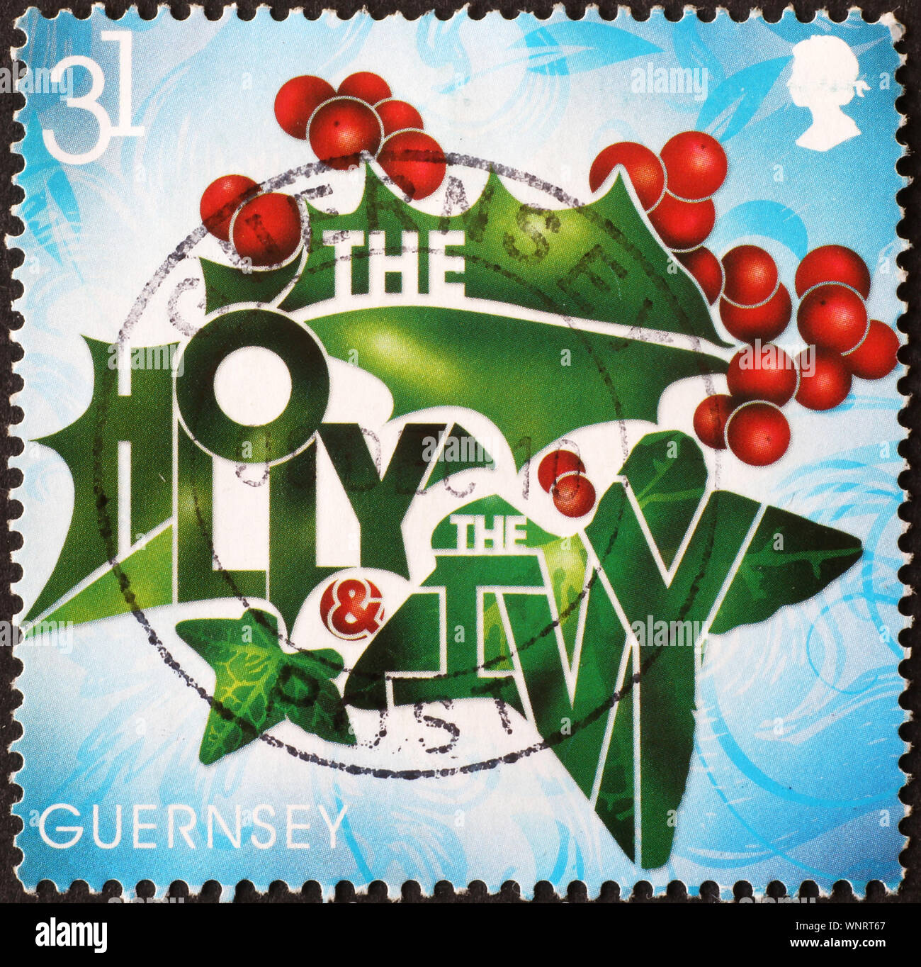 Holly and ivy on postage stamp of Guernsey Stock Photo