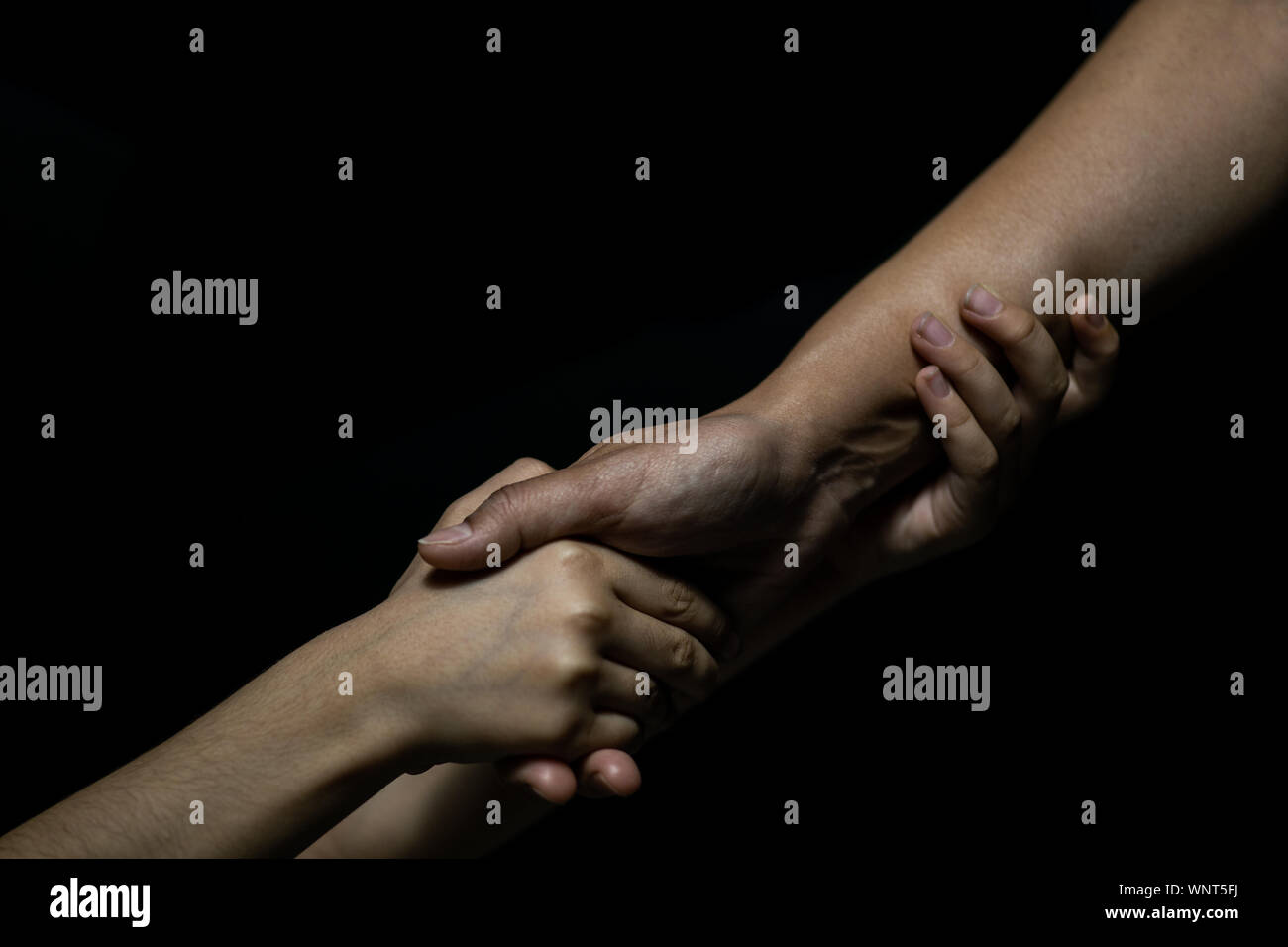 hold hands daughter and mother on black background Stock Photo - Alamy