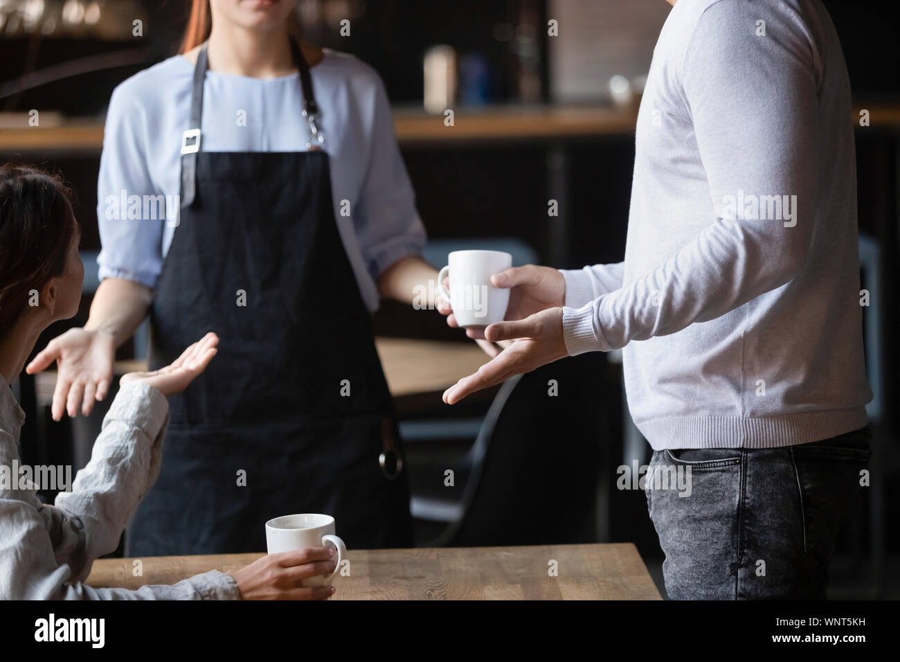 Close up outraged customers arguing with waitress, bad service concept Stock Photo