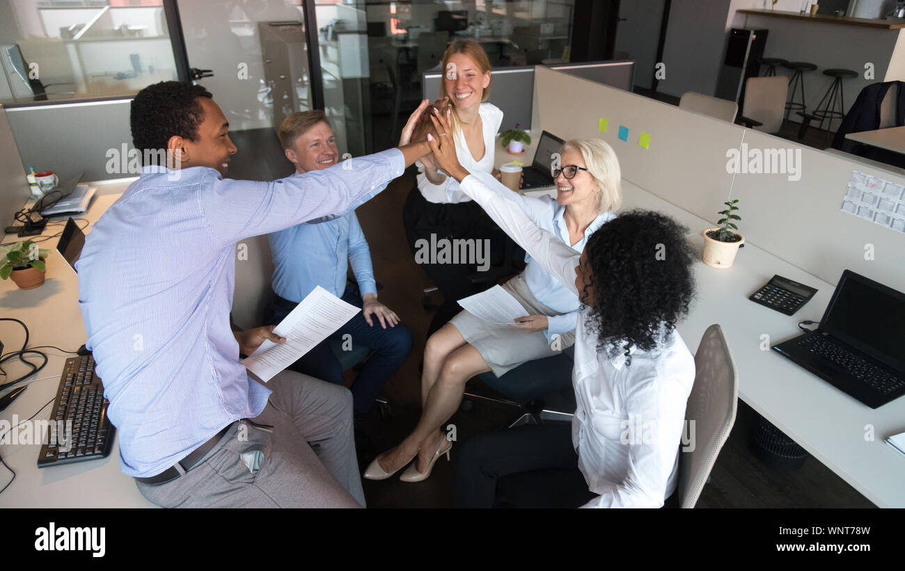 Excited diverse colleagues give high five motivated for success Stock ...