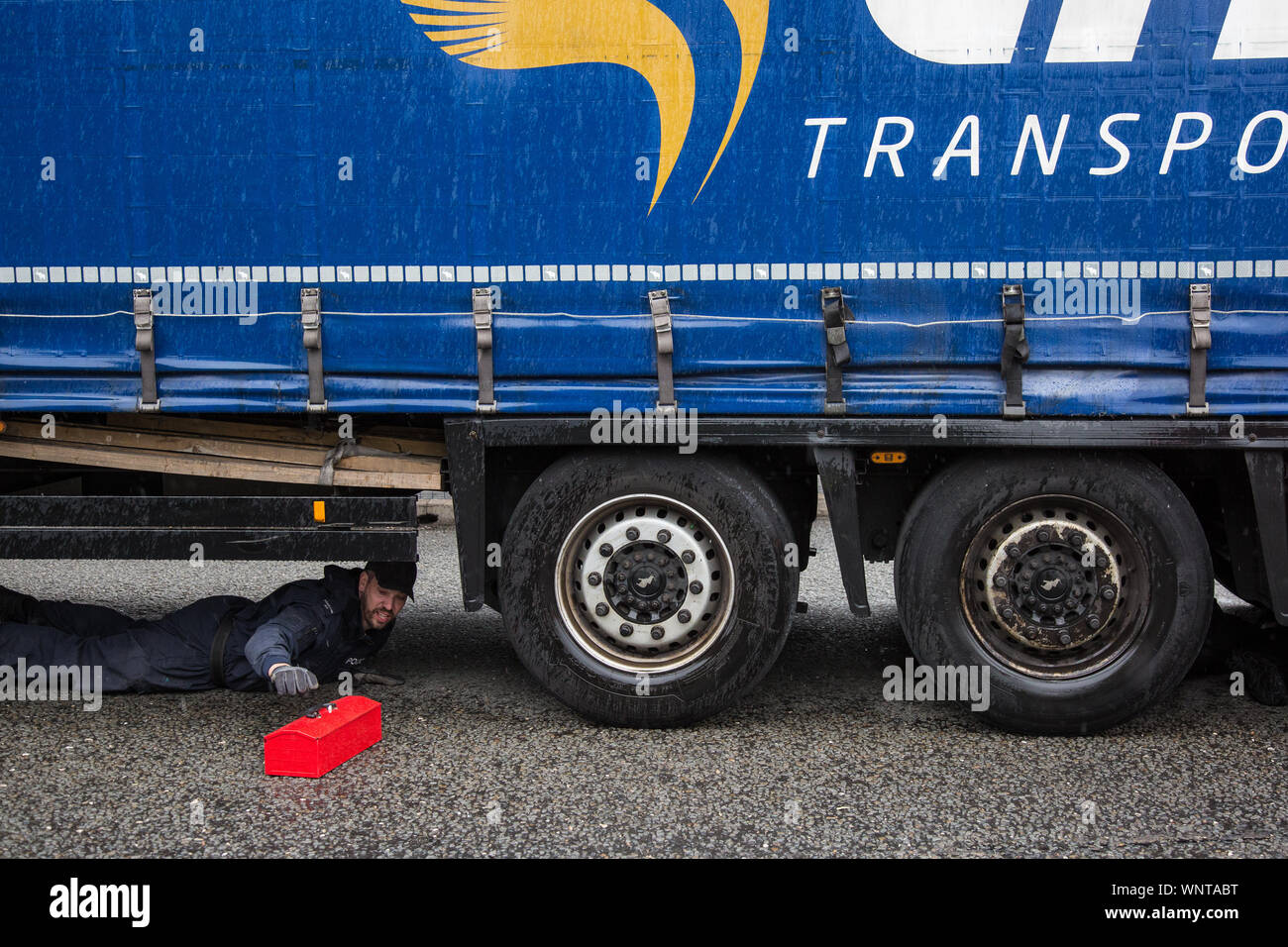 London, UK. 6 September, 2019. A Metropolitan Police officer prepares to remove an activist locked beneath a truck making a delivery to ExCel London for DSEI, the world’s largest arms fair. The road remained blocked for several hours. The fifth day of protests against the arms fair was themed as Stop The Arms Fair: Stop Climate Change in order to highlight links between the fossil fuel and arms industries. Credit: Mark Kerrison/Alamy Live News Stock Photo
