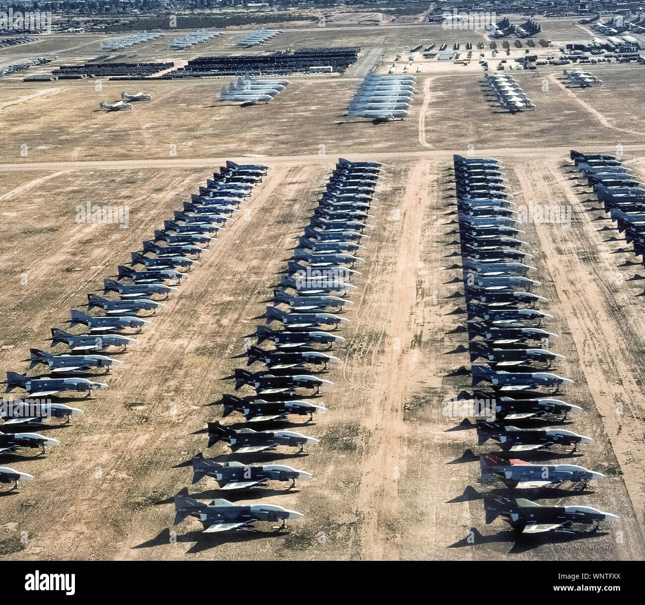 This aerial photograph shows some of the more than 4,400 U.S. military planes mothballed in Tucson, Arizona, at the Davis-Monthan Air Force Base, home to the largest aircraft storage and preservation facility in the world. The boneyard was established after World War II and holds generations of aircraft once used by the U.S. Air Force, Navy, Marine Corps, Coast Guard, NASA and other government agencies. The desert site was chosen because of the area's low humidity, meager rainfall, and high altitude that allows the aircraft to be naturally preserved for cannibalization or possible reuse later. Stock Photo