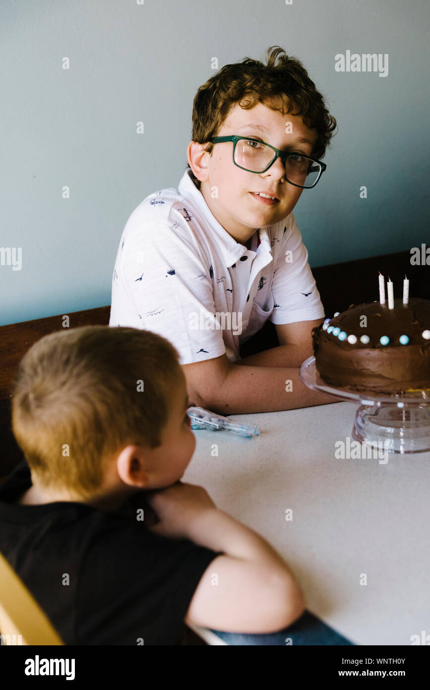Chocolate cake tween birthday celebration with help of his nephew. Stock Photo