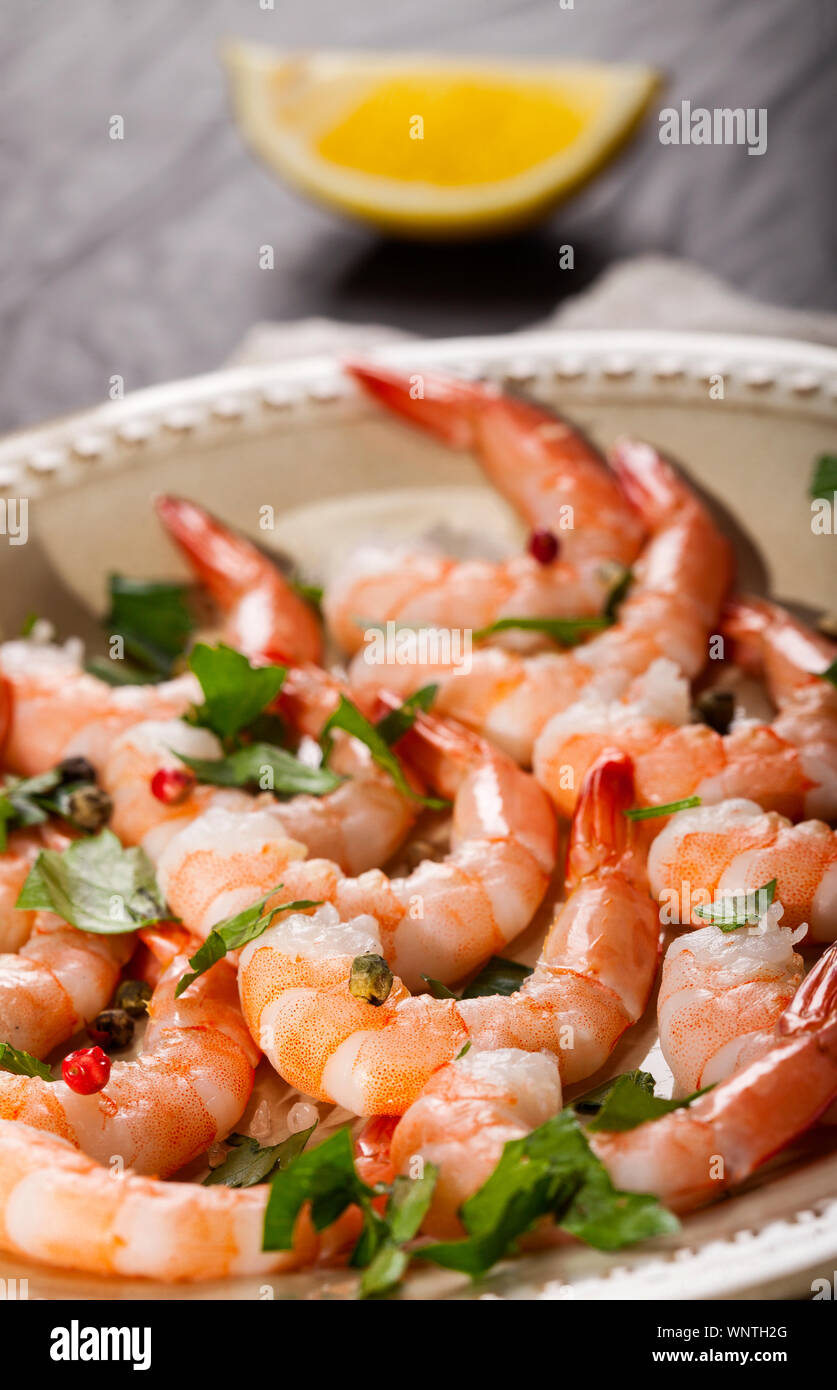 Prawns Shrimps On A Plate With Lemon Garlic And Herbs On Black Stone Background Stock Photo Alamy