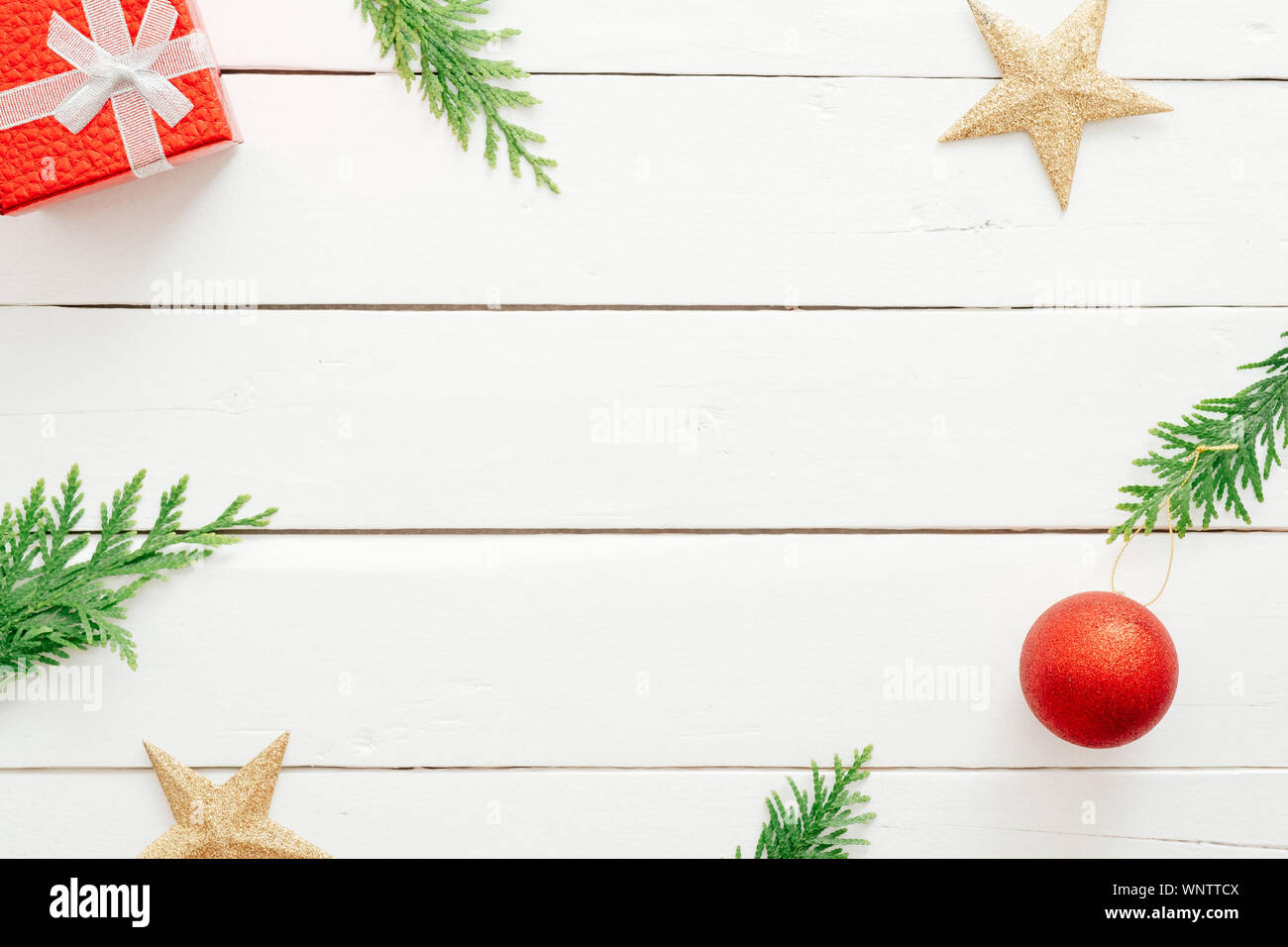 Christmas composition. Christmas decorations, gift box, fir tree branches, on white wooden background. Flat lay, top view, copy space. Christmas or Ne Stock Photo