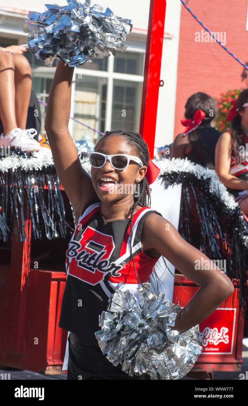 MATTHEWS, NC (USA) - August 31, 2019: A high school cheerleader waves a pom pom during the Labor Day parade held at the annual 'Matthews Alive' commun Stock Photo