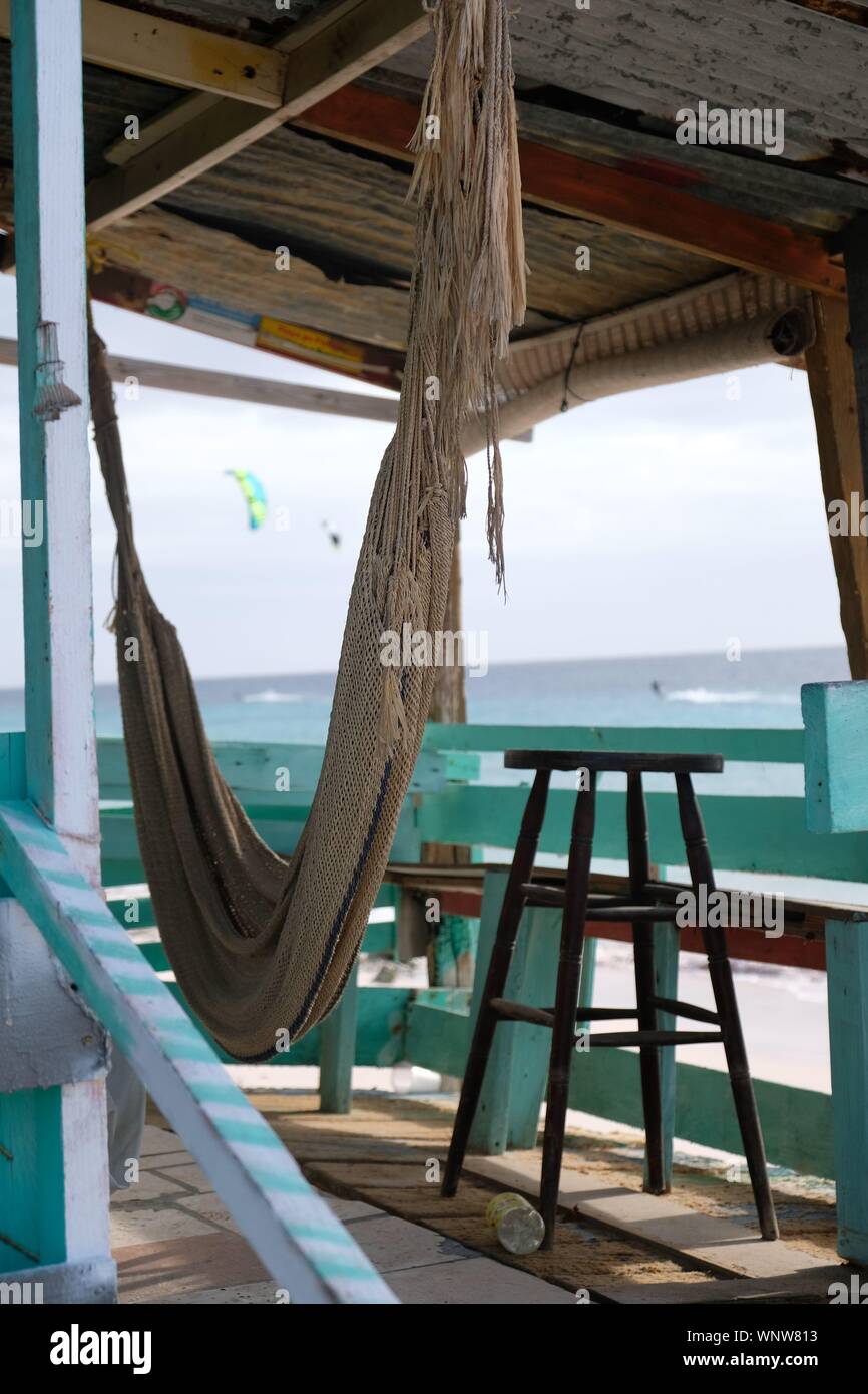 A hammock in an abandoned beach shack with a bar stool Stock Photo Alamy
