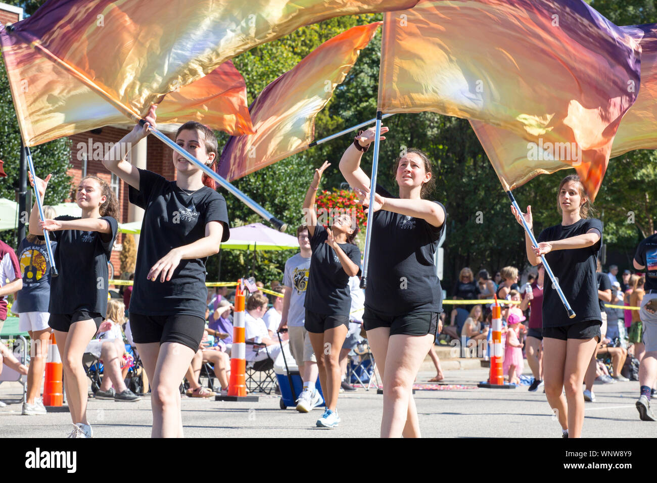 MATTHEWS, NC (USA) - August 31, 2019: High school marching flag wavers perform during the Labor Day parade held at the annual 'Matthews Alive' communi Stock Photo