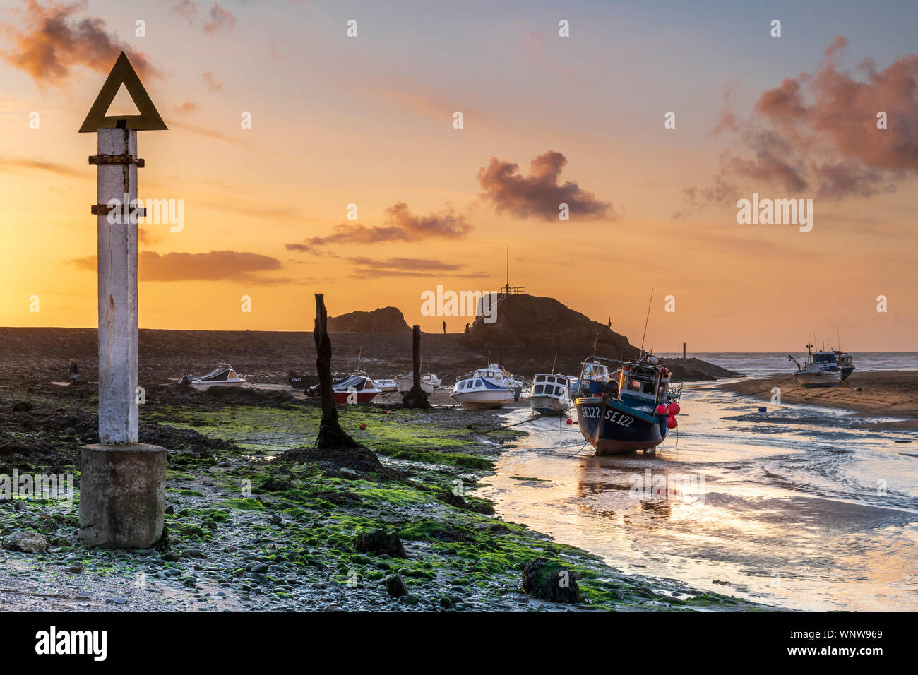 Bude, North Cornwall, England. Friday 6th September 2019. UK Weather. After a day of heavy showers and grey skies in the West of England, most of the holidaymakers have now returned home as the season draws to a close. At dusk the clouds finally clear as the sun sets over the breakwater and little harbour at Bude in North Cornwall. Terry Mathews/Alamy Live News. Stock Photo