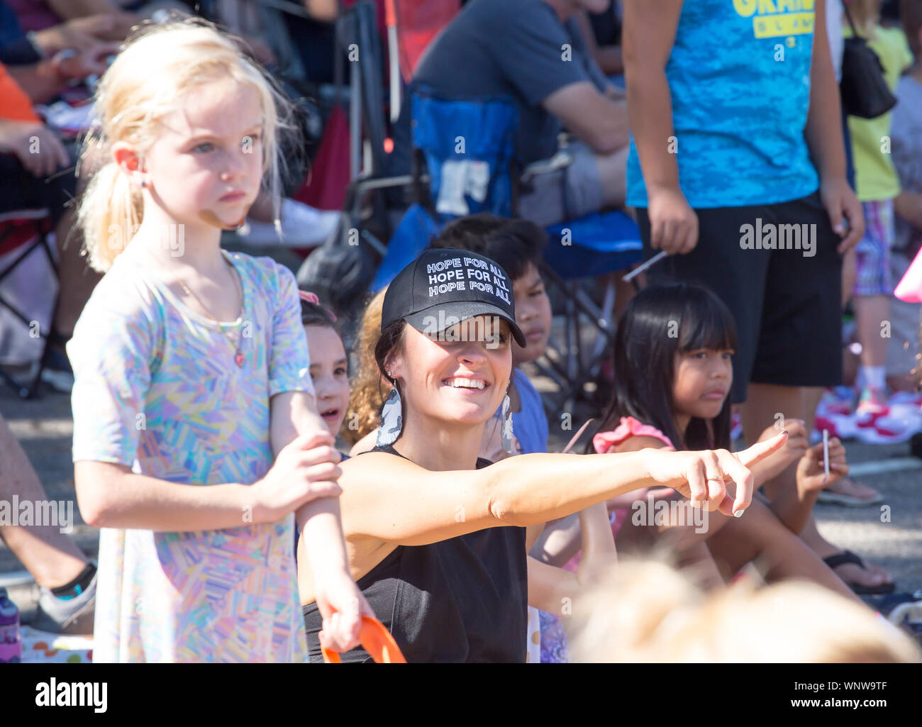 MATTHEWS, NC (USA) - August 31, 2019: Enthusiastic spectators watch the Labor Day parade held at the annual 'Matthews Alive' community festival. Stock Photo