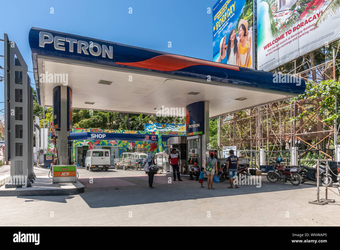Manoc-Manoc, Boracay Island, Philippines - March 4, 2019: Near Cagban Jetty Port and ferry pier. Petron gas statio with people and motorcycles. Stock Photo