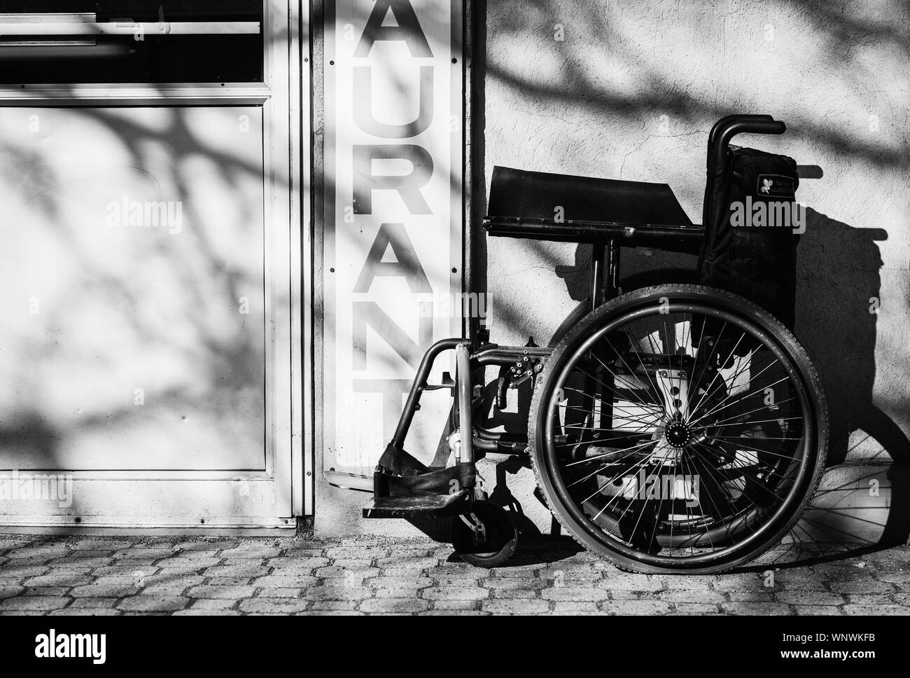 Wheelchair On Cobblestone Street By Wall Stock Photo Alamy