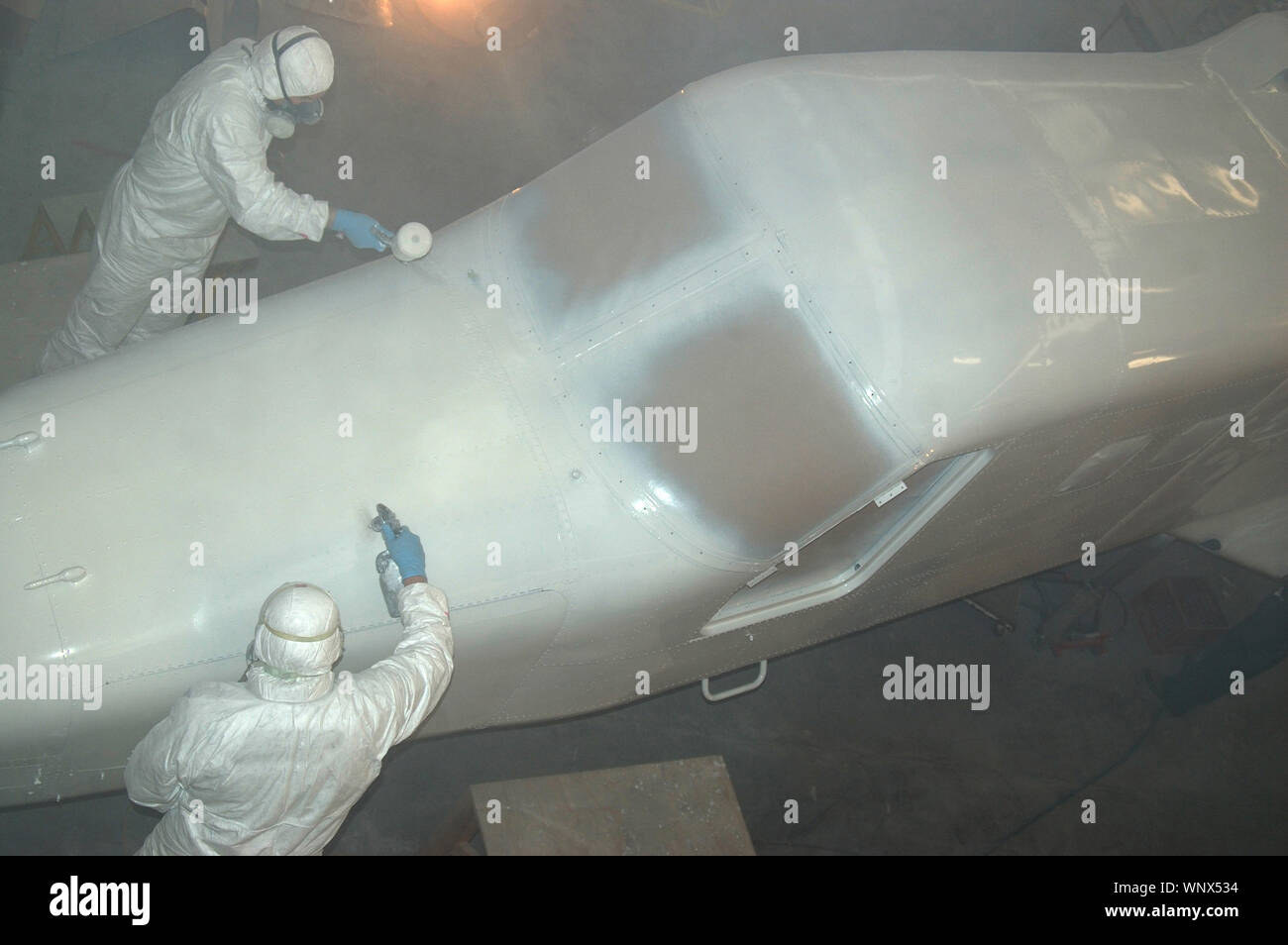 Tradesmen Sprays Top Coat On The Top Of The Nose On A Dornier 228 Aircraft Stock Photo Alamy