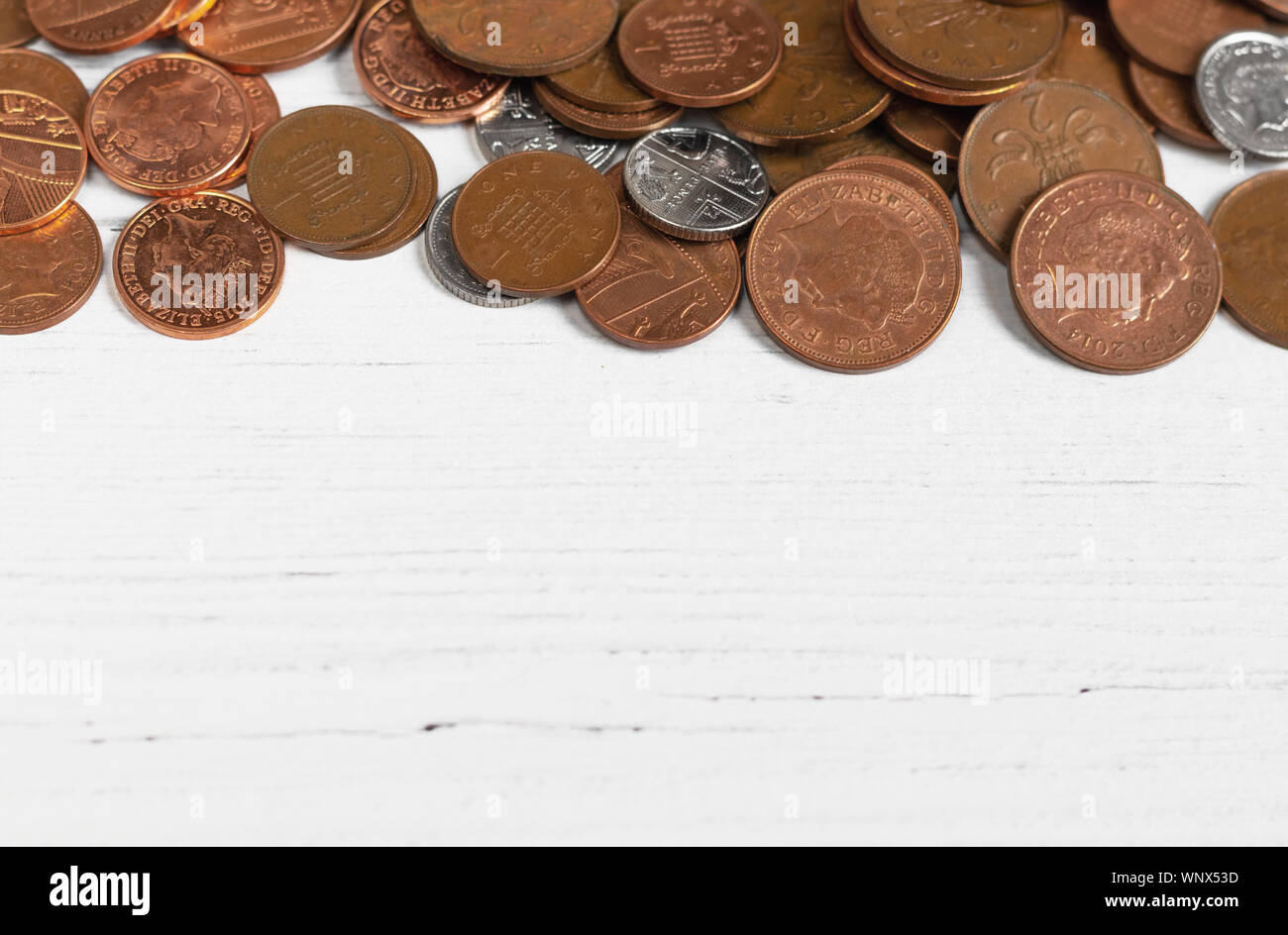 Border of coins on a white table, money savings concept with copy space Stock Photo