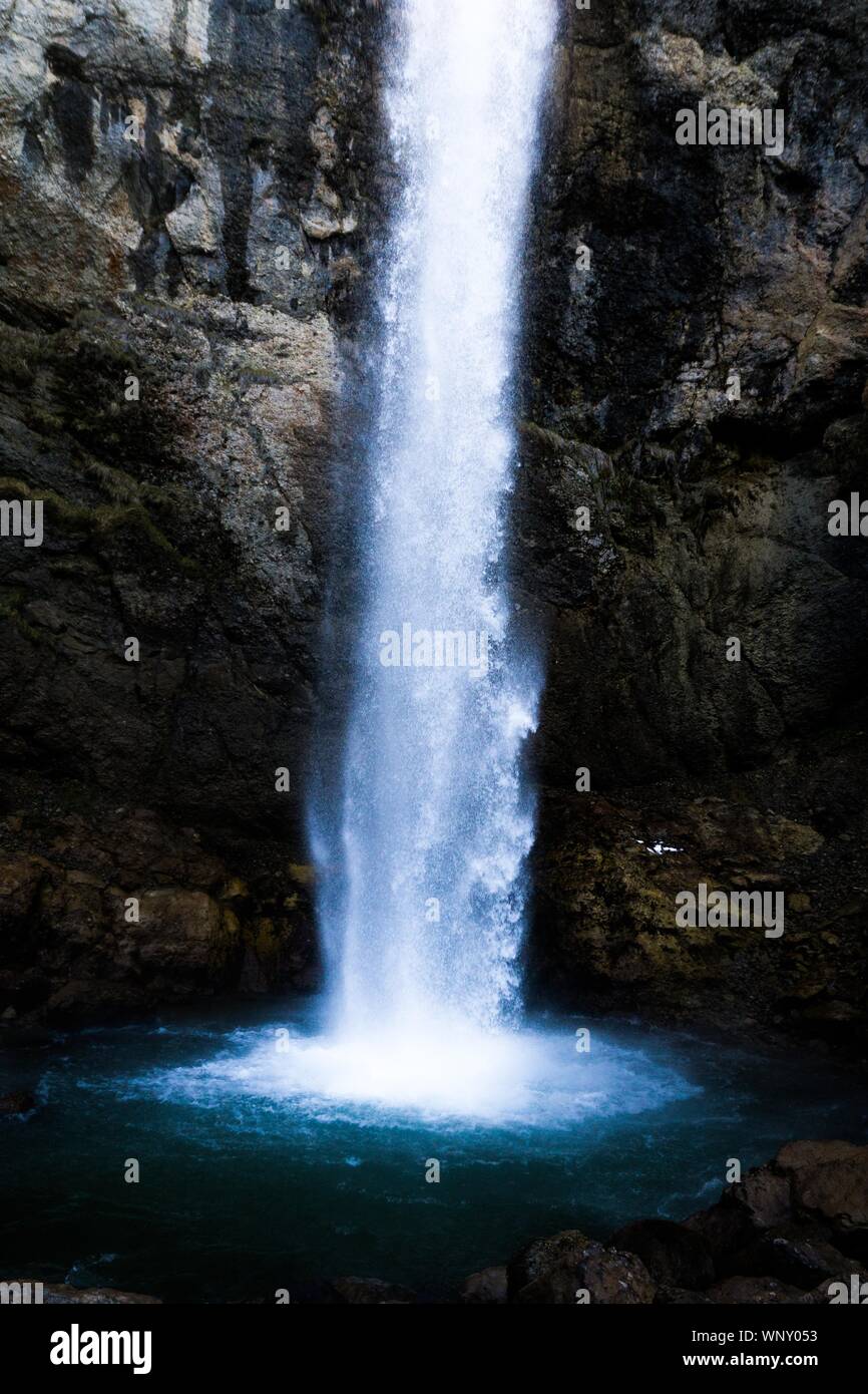 Vertical shot of a waterfall in the middle of the mountain Stock Photo ...