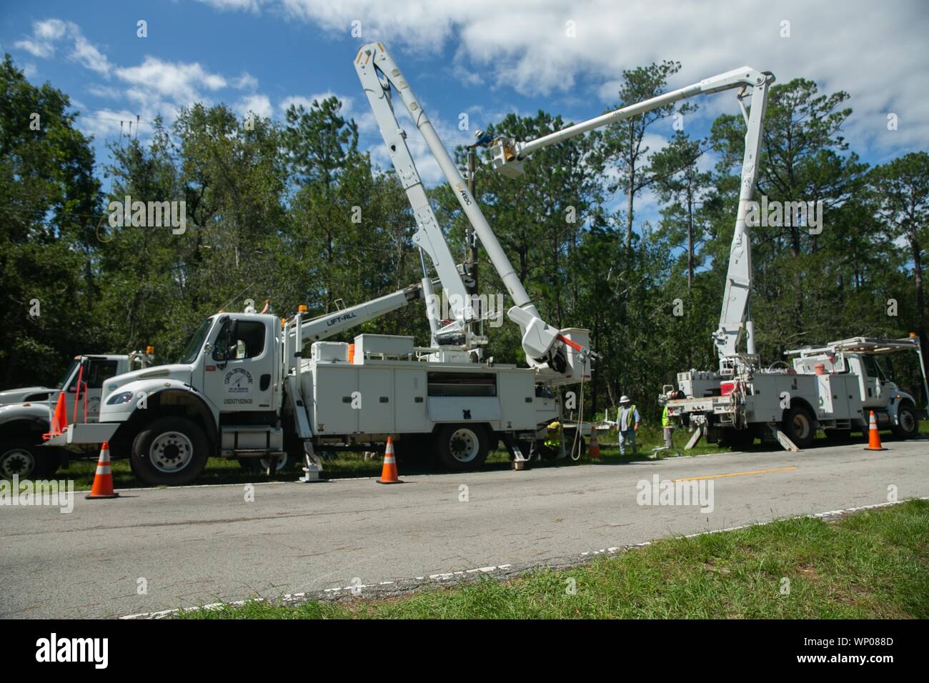 Contracted construction workers replace a damaged power line at Marine Corps Base Camp Lejeune, North Carolina, Sept. 6, 2019. Hurricane Dorian passed by the coast of North Carolina resulting in powerful winds and heavy rain which caused light damage to base facilities. (U.S. Marine Corps photo by Sgt. Abrey Liggins) Stock Photo