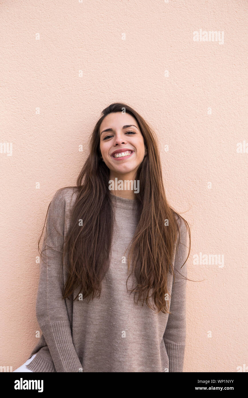 portrait of a smiling woman leaning on a wall in Boadilla del Monte Stock Photo